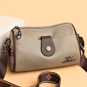 Minimalist khaki leather crossbody bag with floral strap and metal kangaroo logo detail