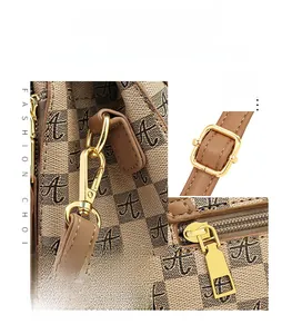 Detailed close-up of khaki checkered handbag showing premium golden hardware and strap