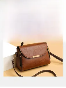 Detailed view of a vintage brown leather handbag with a metallic clasp and elegant handle