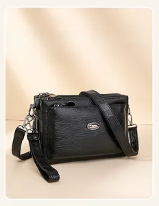 Detail view of the black soft leather crossbody bag with multiple zipper compartments