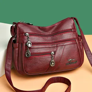 Deep red leather multi-pocket shoulder bag with metal kangaroo logo and crossbody strap