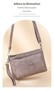 Detail view of multi-compartment gray crossbody bag with textured faux leather and metal buckle