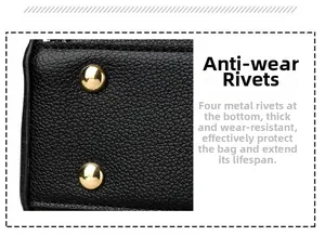Vue détaillée des rivets de protection dorés sur la base en cuir grainé noir du sac à main
