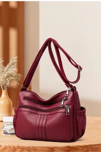 Dettaglio della borsa a tracolla in pelle PU bordeaux con tre tasche con zip e grana fine