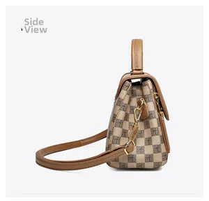 Side view detail of the brown checkered handbag with golden hardware and leather strap