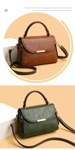 Detail of vintage textured leather crossbody bag with elegant gold rectangular buckle