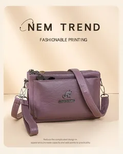 Detalle del bolso bandolera morado con múltiples compartimentos y logo de canguro