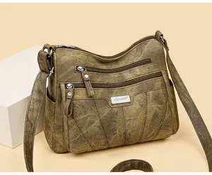 Close-up of vintage textured PU leather handbag featuring three front zipper compartments