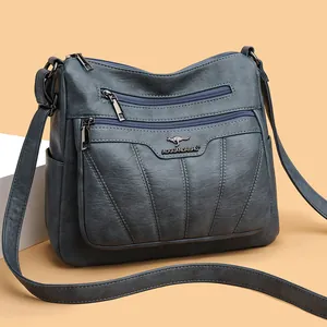 Bolso bandolera azul grisáceo en piel sintética suave con múltiples cremalleras