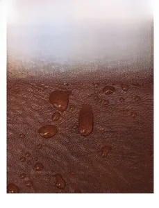 Detailed view of brown lychee texture leather with waterproof water droplets on surface