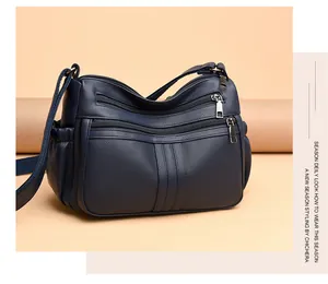 Dettaglio della borsa a tracolla blu scuro in ecopelle con più tasche con cerniera
