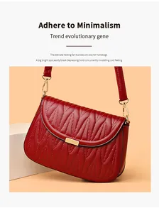 Détail du sac bandoulière bordeaux avec surpiqûres ondulées et boucles dorées en éventail
