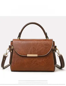 Front view of brown vintage leather crossbody bag with gold metal hardware and top handle