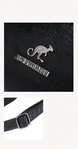Detalle de bolso en piel negra con logo de canguro plateado y hebilla de correa ajustable