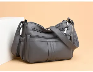 Vista laterale dettagliata della borsa a tracolla grigia in ecopelle con più zip