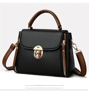 Détail du sac bandoulière bicolore avec fermoir doré et texture cuir grainé