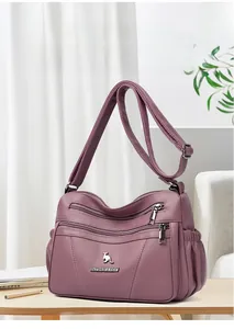 Detail of purple litchi leather bag with multi-zipper layers and kangaroo ornament