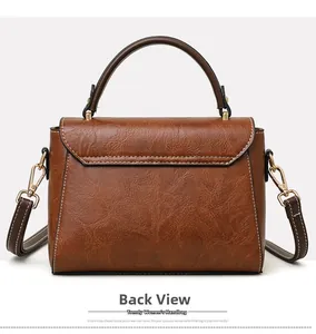 Back view of a vintage brown crossbody bag featuring white stitching and gold hardware