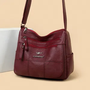 Burgundy quilted leather crossbody bag with multiple zippers and adjustable shoulder strap