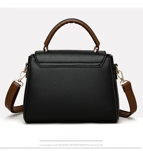 Détails du sac à main noir en cuir litchi avec poignées marron et garnitures dorées élégantes