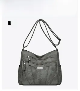 Front view of multi-layer crossbody bag in dark gray PU leather with zipper pockets
