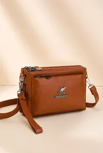 Vista detallada del bolso de cuero marrón multicapa con logo de canguro y bolsillos zip