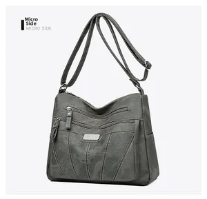 Side view of multi-pocket dark grey shoulder bag with matte texture and metal logo