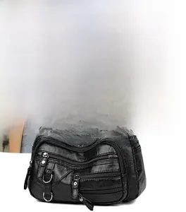 Vue détaillée d'un sac bandoulière noir multi-poches en cuir souple avec une sangle réglable