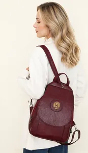Detailansicht des weinroten PU-Rucksacks mit metallischem Logo und Lederstruktur