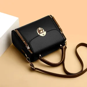 Sac bandoulière tendance en cuir noir grainé avec poignées brunes et boucle dorée
