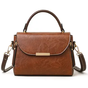 Vintage brown crossbody handbag with top handle and contrast stitching on white background
