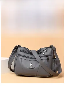 Macro detail of dark grey faux leather bag with double zippers and silver kangaroo logo