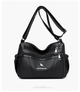 Detail of black faux leather bag featuring three zipper pockets and lychee grain texture