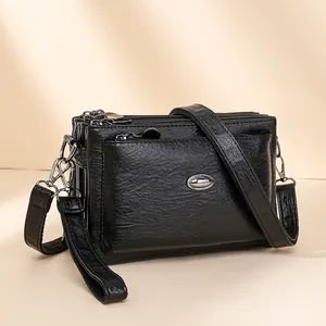 Three-zipper multi-compartment black litchi leather crossbody bag with silver hardware