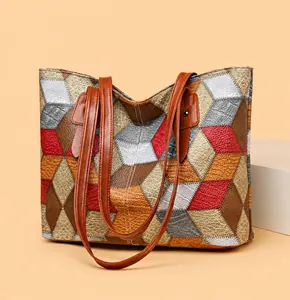 Primer plano del bolso tote geométrico de patchwork con paneles de cuero y correa marrón