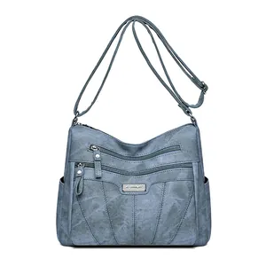 Haze blue multi-layer crossbody bag with adjustable strap and silver metal logo plaque