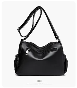 Detailed back view of black lychee leather crossbody bag with multiple zipper compartments