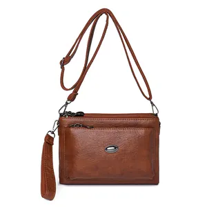 Brown faux leather crossbody bag with multiple zip compartments and adjustable strap