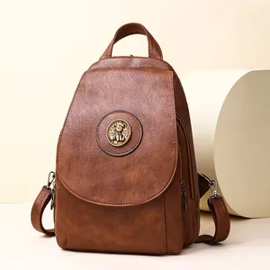 Minimalistischer PU-Lederrucksack in Karamell mit Bären-Metallabzeichen im modernen Studio
