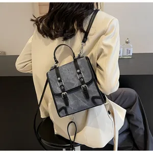 Detailed back view of vintage grey textured satchel with black buckles on casual outfit