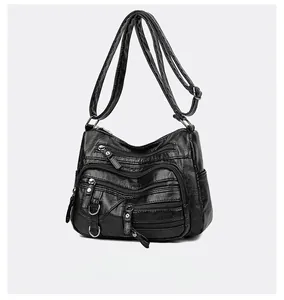 Gros plan du sac bandoulière noir en cuir PU avec plusieurs fermetures éclair et grainé