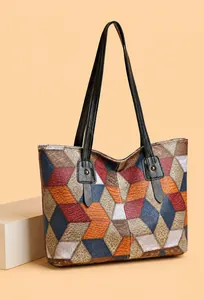 Detalle del bolso tote de bloques de color con cuero granulado y correas remachadas