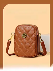 Détail du cuir matelassé marron et du fermoir floral en bronze sur le sac à bandoulière