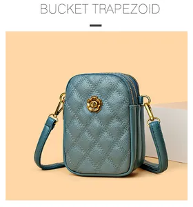 Détail du sac à téléphone matelassé bleu Morandi avec trois zips et pièces en métal doré