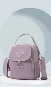 Détail d'un sac bandoulière en nylon violet avec double compartiment zippé et sangle