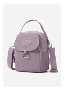 Détail du sac bandoulière en nylon violet avec plusieurs zips et bandoulière réglable