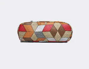 Detalle del fondo del bolso tote de cuero con patrones de costura geométricos de colores