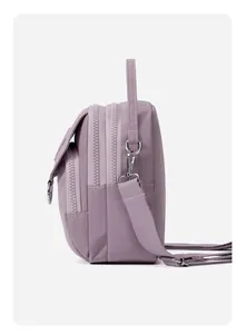 Vue latérale du sac bandoulière en nylon lilas montrant les compartiments zippés et tissus