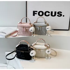 Detail of four stylish bucket bags with silk scarf handles and cute plush charms
