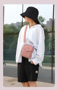 Sac bandoulière en nylon rose avec large sangle réglable et détail anneau sur le rabat